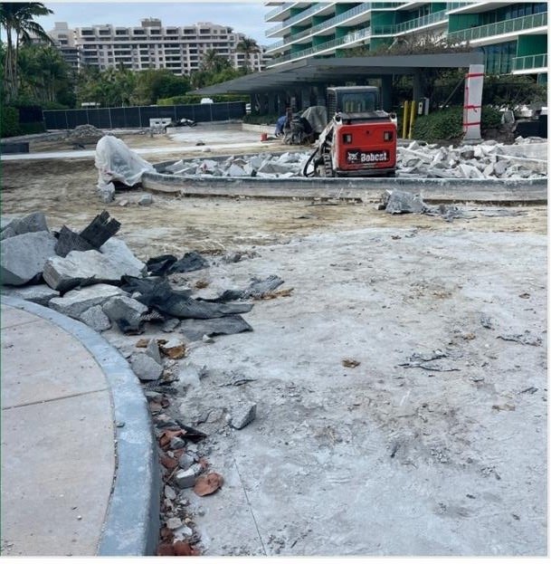 Compact loader performing concrete demolition